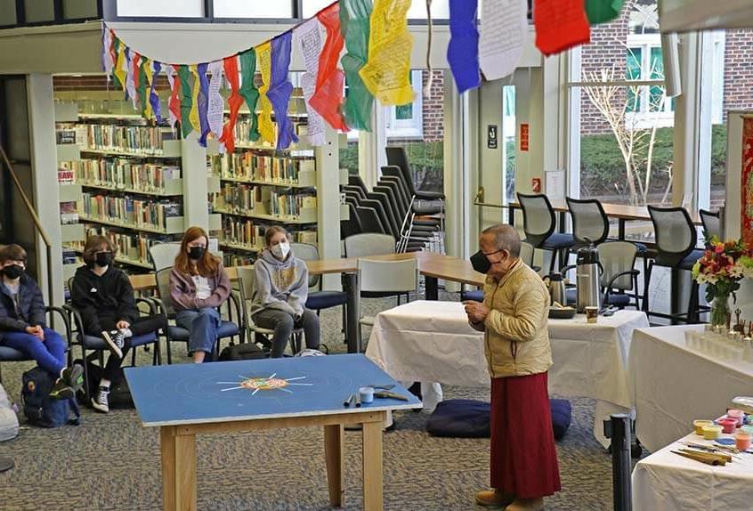 Lama Tenzin visits with students in library