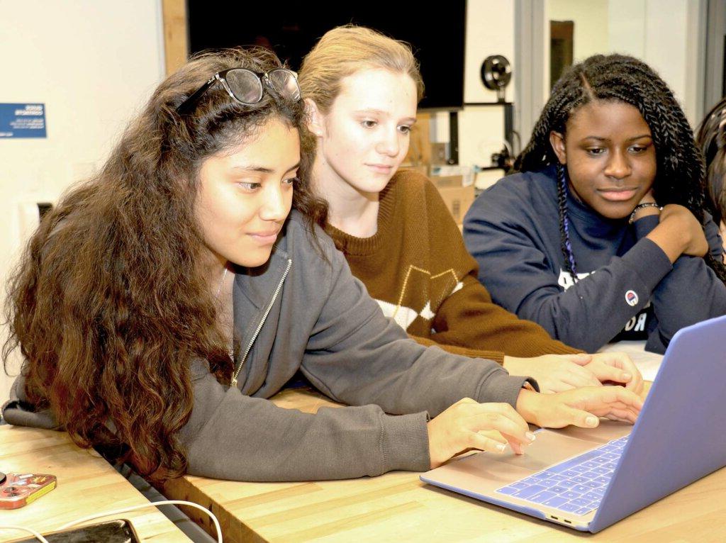 Poly students coding on a laptop