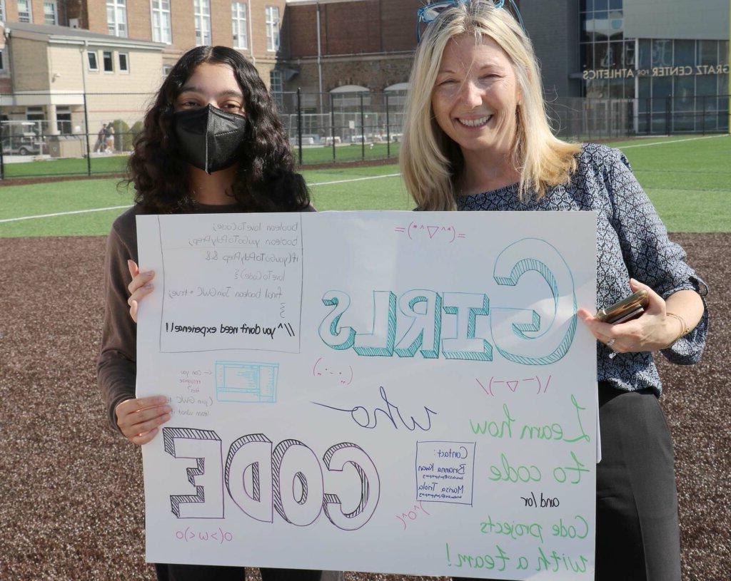 Jean Belford and Marisa Triola holding Girls Who Code sign