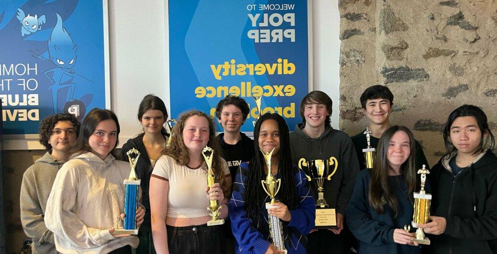 Speech & Debate Team in front of Blue Devil posters