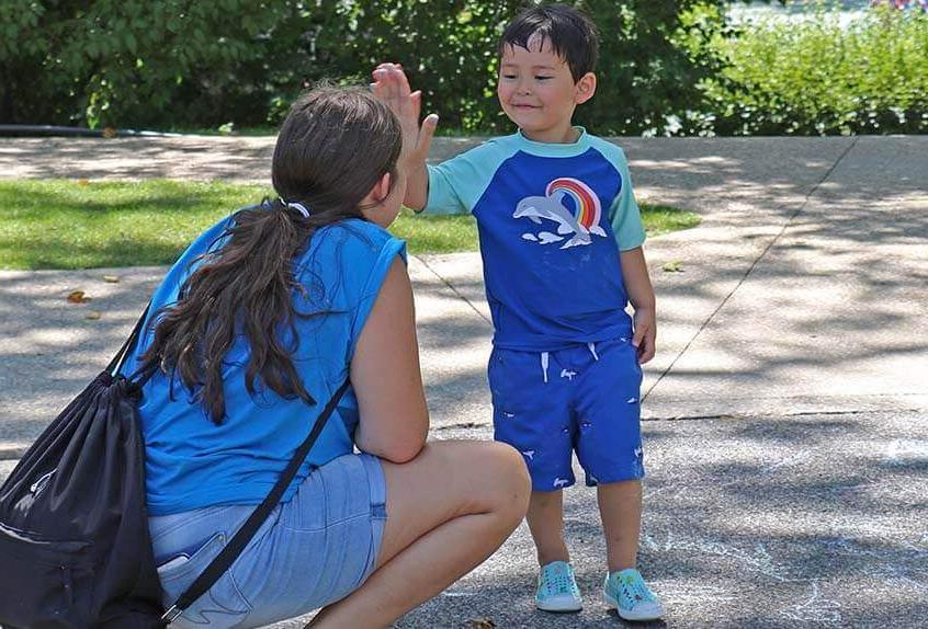 Kid giving counselor high five at Poly Summer day camp