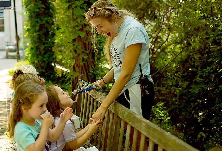 Smiling counselor with kids at Poly Summer day camp