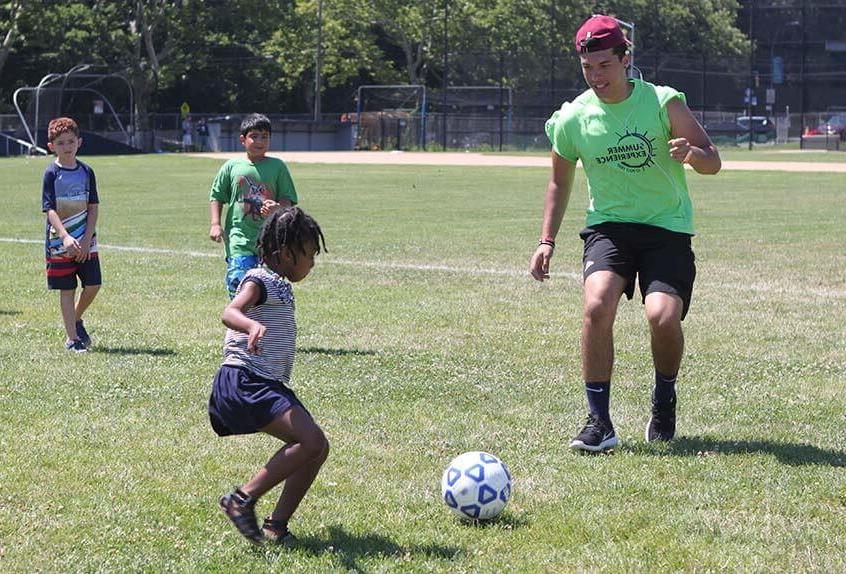 Girls and boys playing soccer at Poly Summer day camp