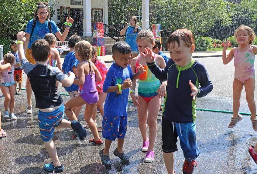 Kids enjoying sprinkler at Poly Summer day camp