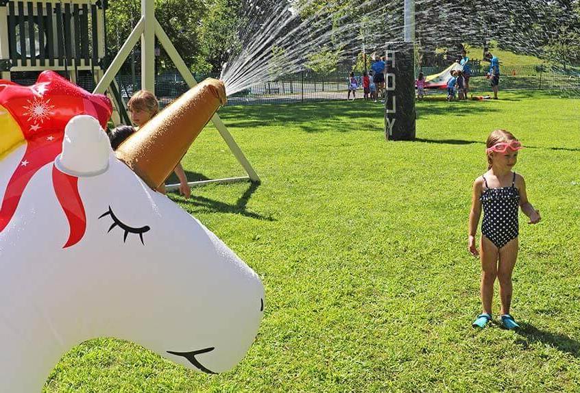 Girl enjoying unicorn sprinkler at Poly Summer day camp